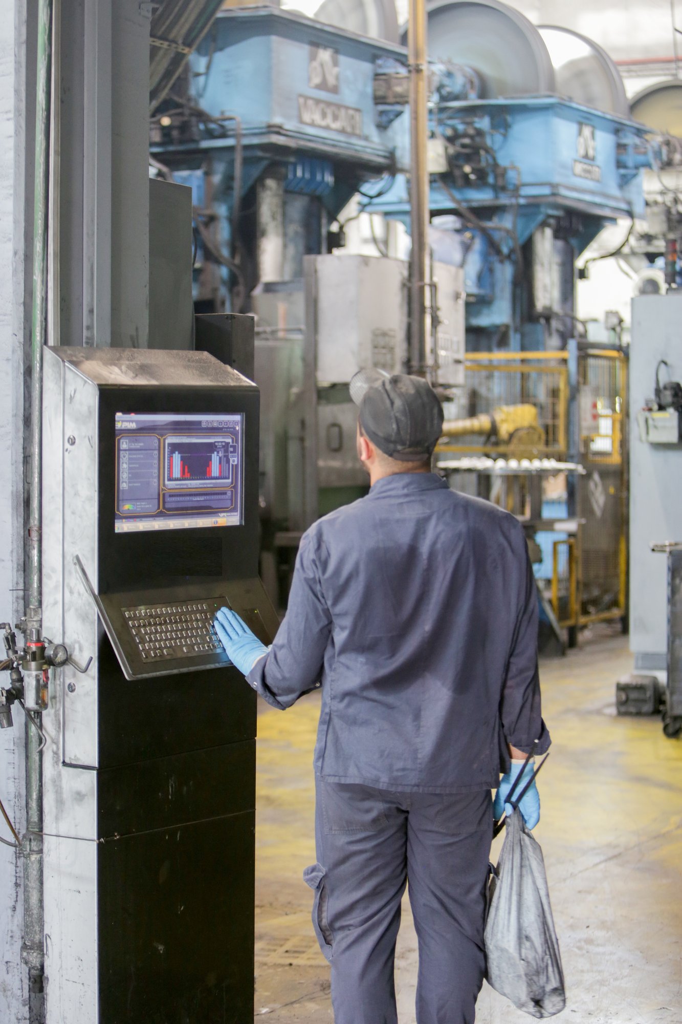 Operator checking the next order on a Visual Factories kiosk between the presses