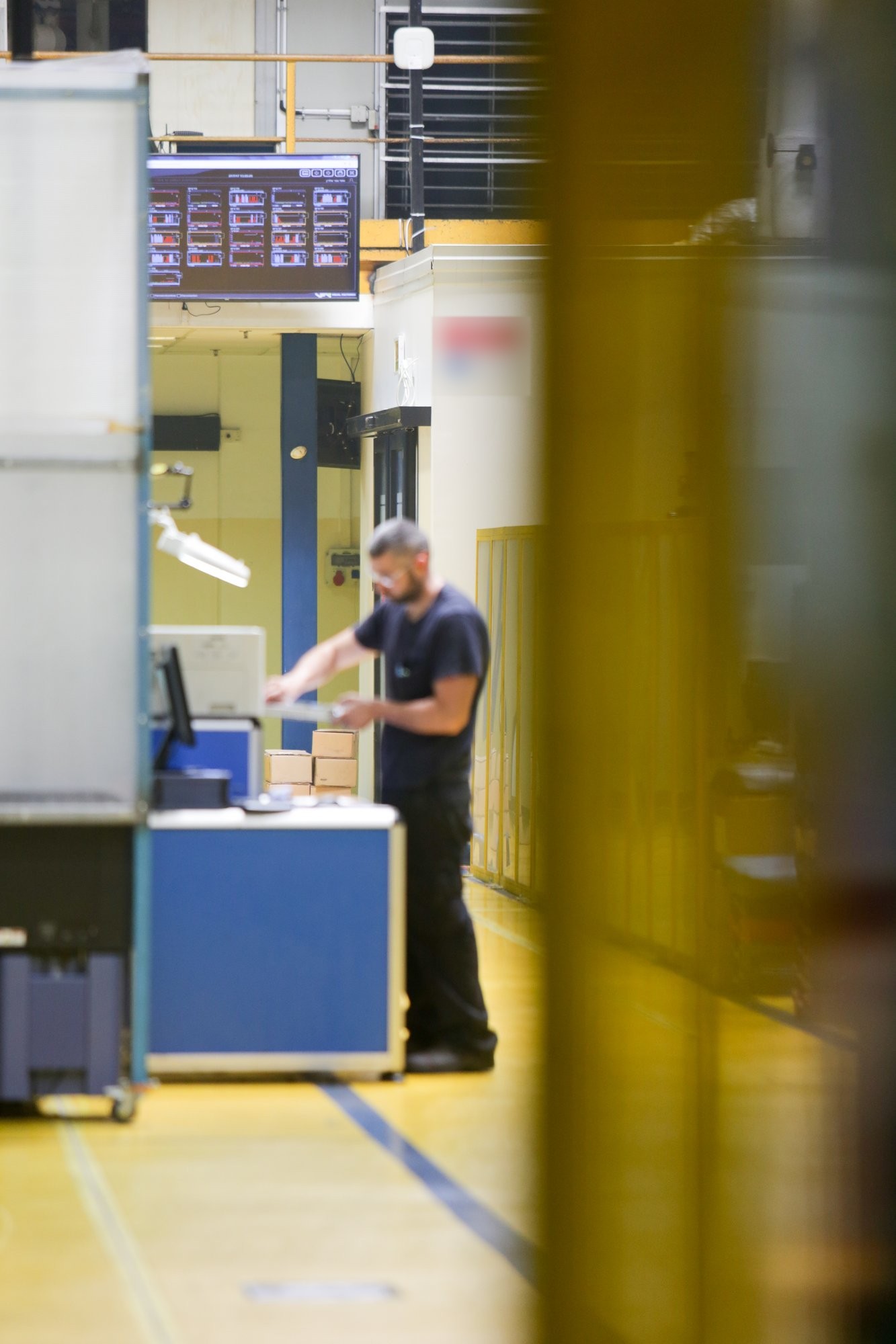 Operator at a Visual Factories station beside the press